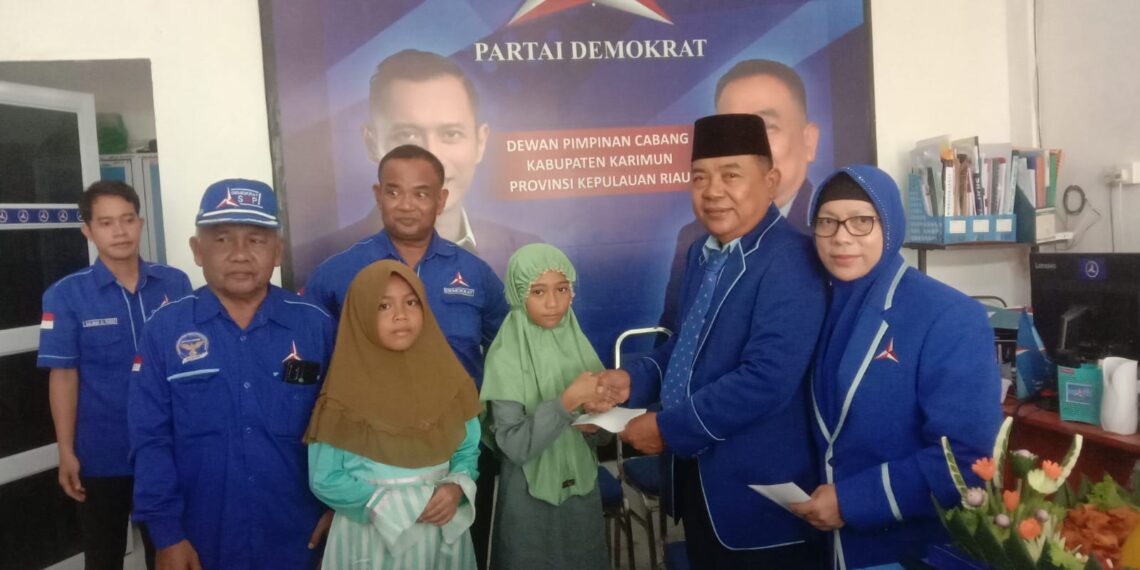 Ketua DPC Partai Demokrat Karimun Sumardi saat memberi bantuan tali asih kepada anak yatim piatu saat acara HUT ke-22 partai Demokrat. (Foto: Defran/lidiknusantara.com)
