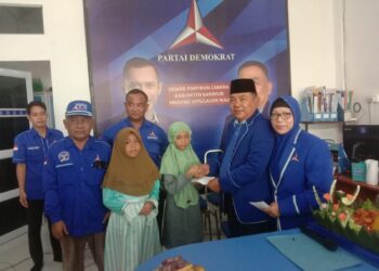 Ketua DPC Partai Demokrat Karimun Sumardi saat memberi bantuan tali asih kepada anak yatim piatu saat acara HUT ke-22 partai Demokrat. (Foto: Defran/lidiknusantara.com)
