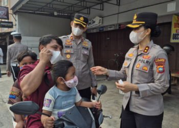 Kapolres Karimun Yunita Stevani membagikan masker dan mengatur lalu lintas, lalu mengedukasi pelajar SMPN 1 Karimun tentang bullying dan narkoba.