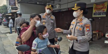 Kapolres Karimun Yunita Stevani membagikan masker dan mengatur lalu lintas, lalu mengedukasi pelajar SMPN 1 Karimun tentang bullying dan narkoba.